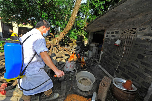 A medical worker sprays disinfectant in a village after torrential rain in Qionghai, Hainan province, on Tuesday. Luo Yunfei / For China Daily