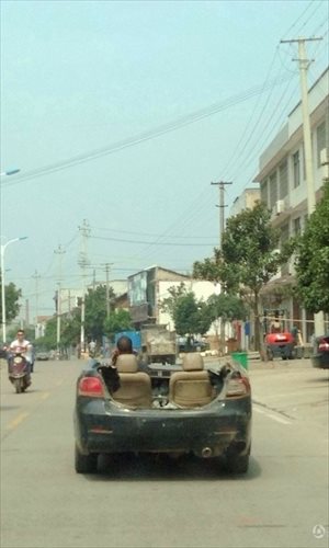 A man makes a phone call while driving a scrapped car in Changsha, Hunan province. Photo: myhn.qq.com