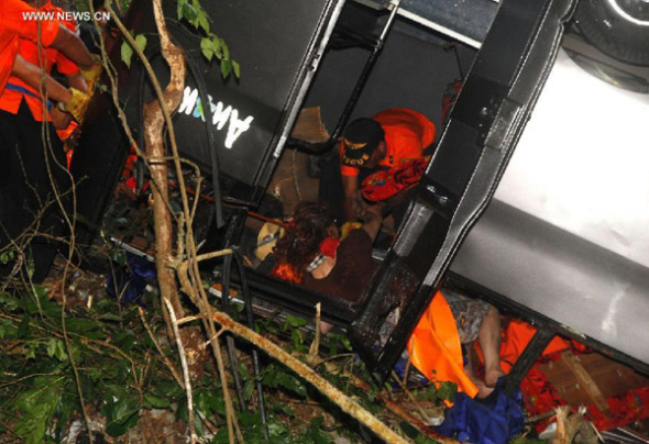 Rescuers try to evacuate victim at the accident site in Bali, Indonesia, on Nov. 18, 2013. A bus carrying 13 Chinese tourists plunged into a ravine near Uluwatu, Bali, killing three of tourists, the Consulate General Office of PRC in Surabaya of East Java confirmed. (Xinhua/Indonesia Press Foto)