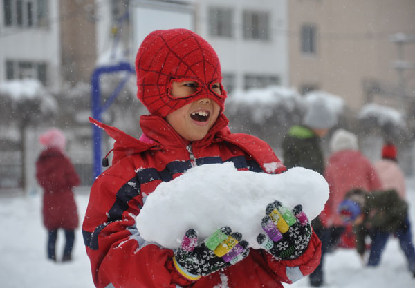 A boy has fun in the snow at a primary school in Jilin city, Jilin province. Wang Mingming / for China Daily