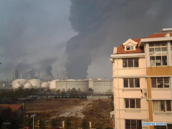 Photo taken with a mobile phone shows the site of a pipeline explosion in Qingdao, east China's Shandong Province, Nov. 22, 2013. A fire broke out and the blast occurred around 10 a.m. in the Huangdao District when workers were repairing a petroleum pipeline which broke and resulted in an oil leakage around 3 a.m.  (Xinhua)