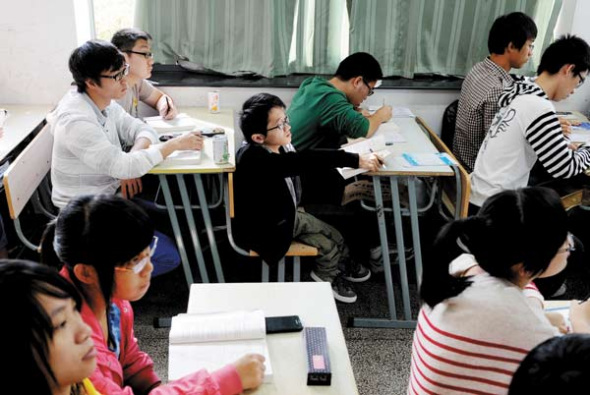 Wu Jia, born with brittle-bone disease, attends a class at the Institute of Jiaxing in Jiaxing, Zhejiang province. Wu was enrolled by the institute's economics department in 2012 with a score of 600 in the national college entrance exam. China Photo Press