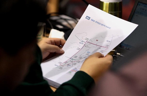 A media reporter of the Republic of Korea holds a map of an expanded air defense identification zone (KADIZ) during a press conference for an expanded KADIZ at the Ministry of National Defense in Seoul, Dec 8, 2013. [Photo/Xinhua]