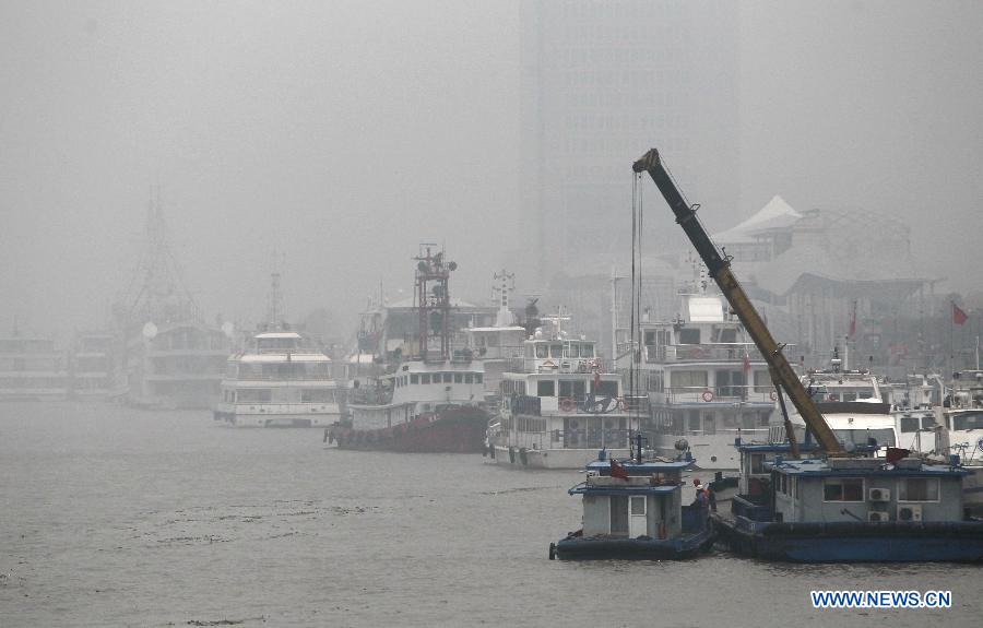 The Shiliupu Dock is blanketed by fog and smog in Shanghai, east China, Dec. 9, 2013. Heavy smog and fog continued to hit Shanghai on Monday. (Xinhua/Pei Xin)