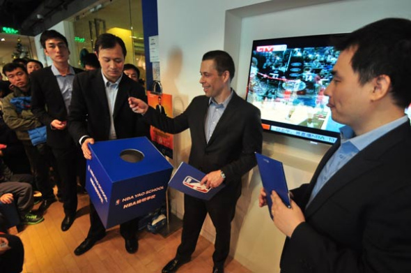 NBA China CEO David Shoemaker (center) draws a lottery to award a lucky student with NBA gift at the event.[Photo by Sun Xiaochen / chinadaily.com.cn]