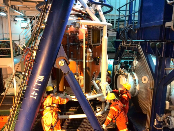 Workers fix the deck of a ship ahead of a diving mission, Jan 12. China succeeded in its first 300-metre saturation diving on Sunday morning as three divers returned safe and sound from deep water to the living chamber on the ship. [Photo/Xinhua]