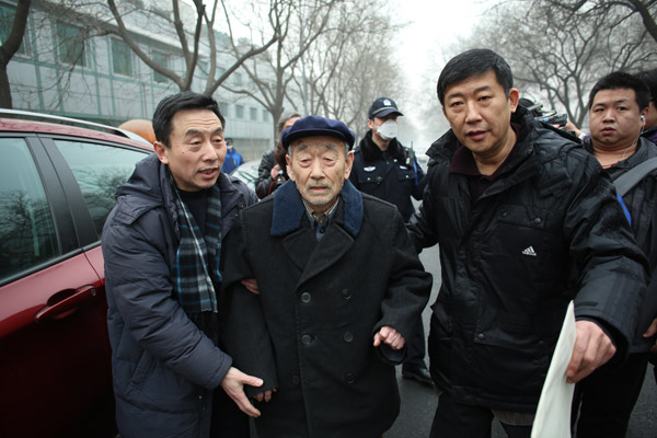 Zhang Shijie (center), 88, who was forced to work as a laborer in Japan in 1944, arrives at Beijing No 1 Intermediate Peoples Court on Wednesday. Wang Jing / China Daily