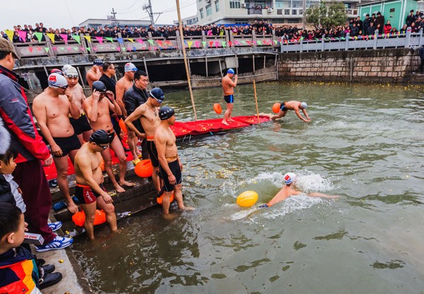 More than 50 bosses from factories that produce rubber shoes take a dip in a river in Rui'an, Zhejiang province, on Monday to raise awareness of the environment and highlight their efforts to reduce pollution generated by their manufacturing operations. ZHAO YONG / FOR CHINA DAILY