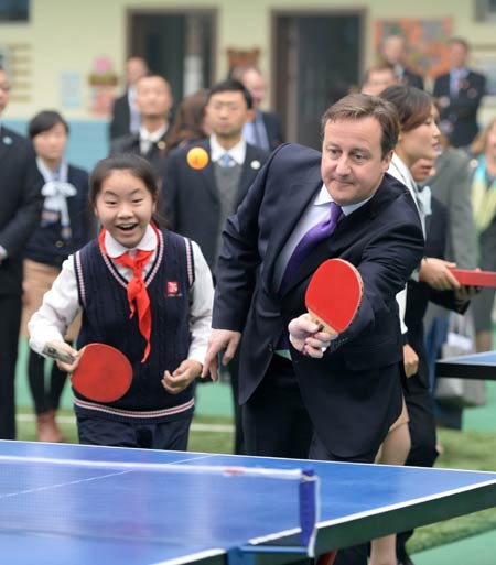 British Prime Minister David Cameron plays table tennis with pupils at a primary school during his visit to the provincial capital in 2013. Wang Xiwei / for China Daily