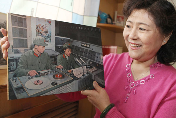 Ni Wen holds a photograph of herself at work at the frontier broadcasting station in Xiamen, Fujian province, in 1976. ZHU XINGXIN / CHINA DAILY 