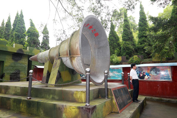 A visitor poses in front of a loudspeaker on display in Xiamen. The horn is believed to be the worlds largest military broadcast speaker. LAN TIANYI / FOR CHINA DAILY 