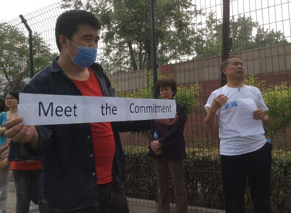 Family members of Chinese passengers aboard the missing Malaysia Airlines Flight MH370 gather at the Malaysian embassy in Beijing on Friday to ask the Malaysian government to continue sending representatives to the daily briefing that has kept them informed. They said no one has come for three days. Zhu Xingxin / China Daily