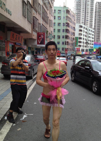 A man surnamed Lian sets out to propose to his girlfriend whilst wearing pink lingerie in Dongguan, south China's Guangdong province, May 14, 2014.