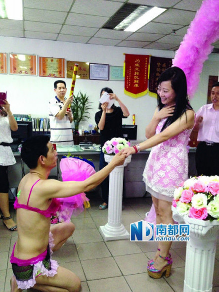 Lian's girlfriend, surnamed Liao, is surprised by her boyfriend's outfit when she walks into a room that has been decorated with flowers on May 14, 2014. [Photo: nandu.com]  