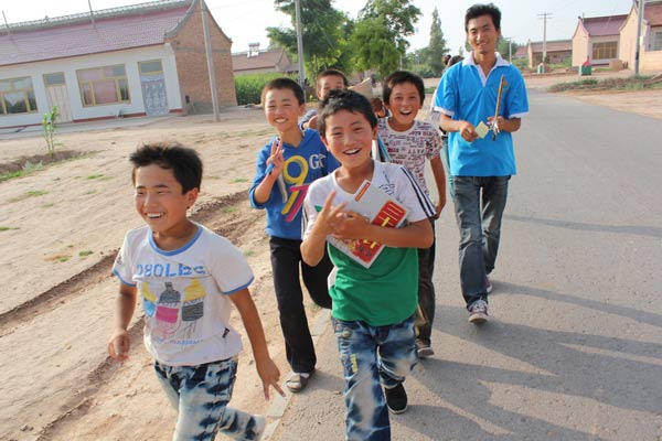 Children from impoverished families in Northwest Chinas Ningxia Hui autonomous region, are helped by a volunteer from Project Sunrise, which provides assistance with educational issues. PROVIDED TO CHINA DAILY 