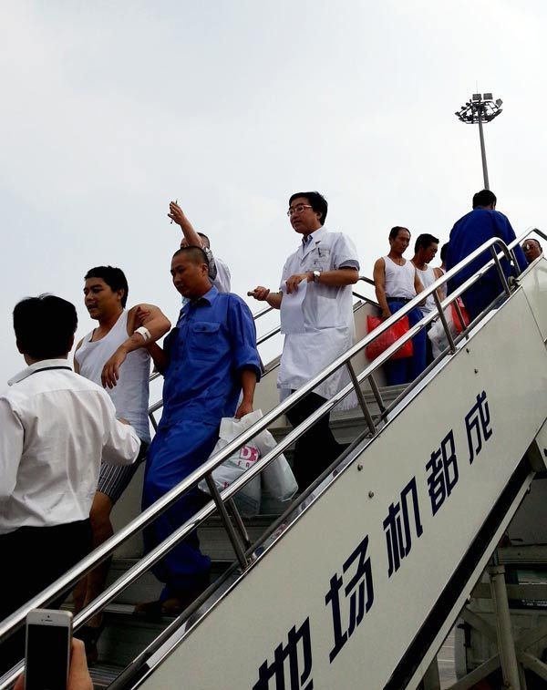 Chinese workers arrive at Chengdu airport on Sunday aboard a flight chartered by the government. HAI MINGWEI/ XINHUA 