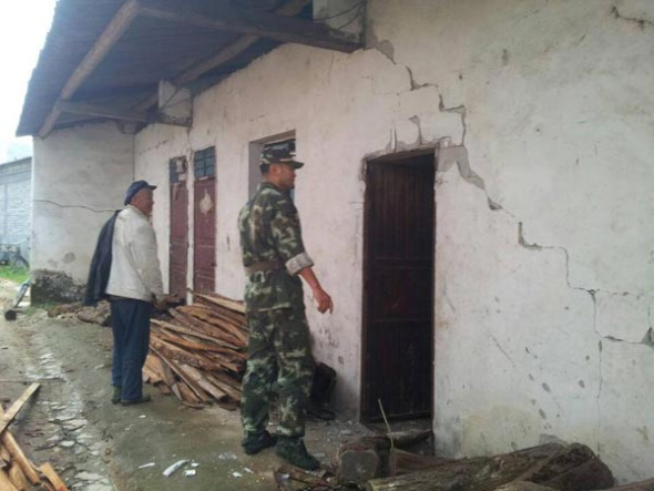 A rescuer (R) inspects a damaged house after an earthquake jolted Yingjiang county of Southwest China's Yunnan province at 4:49 am Saturday. [Photo/Xinhua]