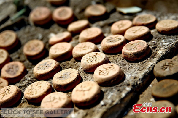 Tens of Chinese chess pieces, used by ancient soldiers, are found during the Great Wall of Ming Dynasty repair work at Funing county in Qinhuangdao city of north China's Hebei province on May 5, 2014. [Photo/CFP] 