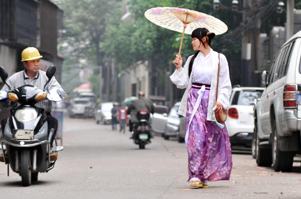 Long Jiayan walks on the streets of Changsha wearing the hanfu. Li Jian / For China Daily