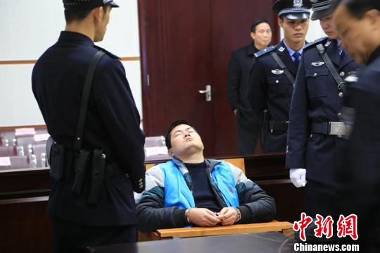 Photo taken on Feb 17 shows Hu Ping, a former policeman in Guangxi Zhuang Autonomous Region, on trail at Guigang Intermediate People's Court. (File photo/ Chinanews.com)