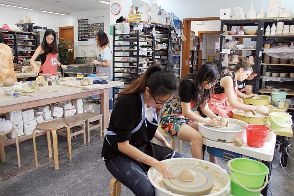Isabel Frey (far right) joins fellow workshop students at the potter's wheel. Photos by Yu Ran / Shanghai Star