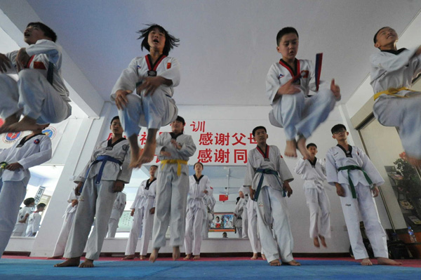 Middle school students in Yuncheng, Shanxi province, learn kickboxing from a coach during summer vacation. Photo by Gao Xinsheng / For China Daily