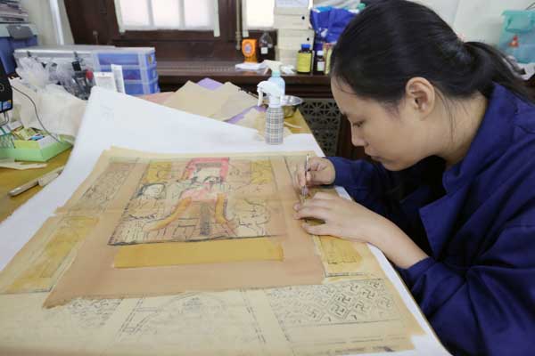 Restorers of ancient books work as book doctors at the National Library of China in Beijing. [Photo by Jiang Dong / China Daily]