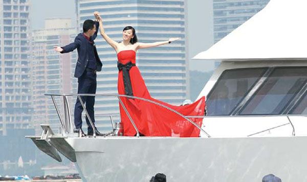 A newlywed couple poses for wedding photos on a yacht at the Qingdao Olympic Sailing Center, Shandong. Zhang Wei / China Daily