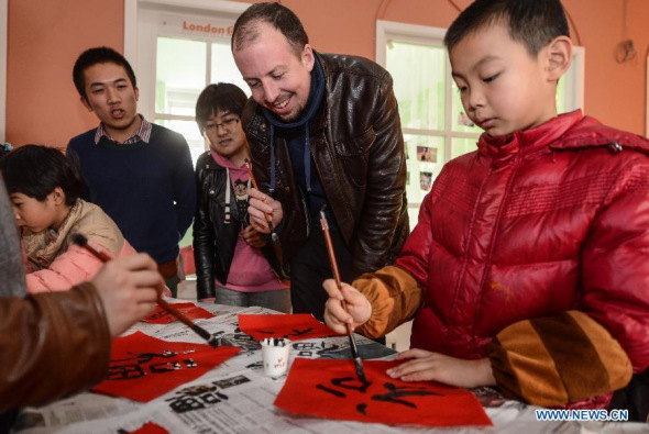 A foreign teacher from the United States learns writing Chinese character in Hangzhou, Zhejiang Province, Jan. 20, 2014. [Photo: Xinhua]
