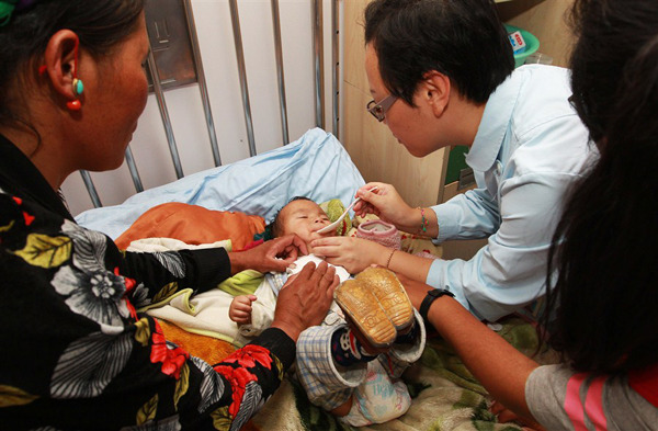 A Tibetan baby is fed medication at the Childrens Hospital affiliated to Fudan University in Shanghai yesterday. Fifteen children aged from 4 months to 10 years arrived in the city with their families from their homes in southwest Chinas Tibet Autonomous Region for treatment to congenital heart defects under a charity scheme. They will have surgery at the hospital and two other facilities.  Xinhua