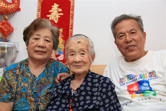 Shanghais oldest resident, 115-year-old Li Suqing (center), poses for a photograph at home yesterday, flanked by her daughter, Tian Yulan, 74, and son-in-law, Gong Jingfa, 76.  Zhang Suoqing