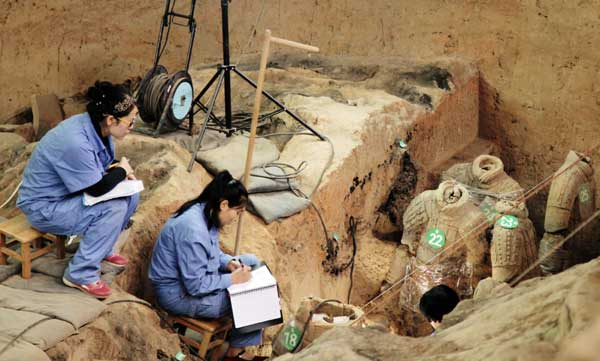 In Pit 1, behind rows of warriors, archaeologists compile a detailed file for each soldier that is brought to light. [Photo by Fan Zhen/China Daily]