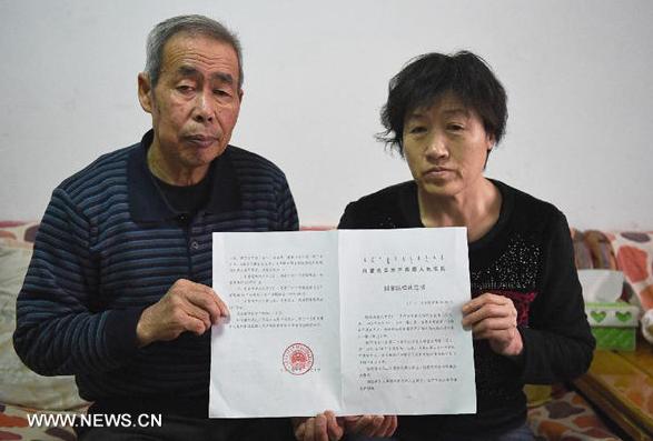 Li Sanren (L) and Shang Aiyun, parents of Huugjilt, who was wrongly executed for rape and murder at age 18, show the verdict of state compensation totaling more than 2 million yuan (about 322,000 U.S.dollars) in Hohhot, capital of north China's Inner Mongolia Autonomous Region, on Dec. 31, 2014. On Dec. 15, 2014, the Inner Mongolia Autonomous Regional Higher People's Court overturned Huugjilt's previous conviction and ruled he was not guilty of rape and murder, saying that the facts of his case were unclear and evidence was inadequate. (Xinhua/Shao Kun)