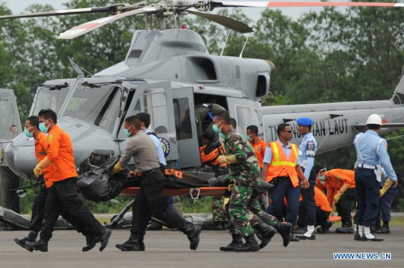 Search and Rescue (SAR) personnel move bodies retrieved from scene of crashed AirAsia flight QZ8501 from Indonesian Navy helicopter at Iskandar Air Base in Pangkalan Bun, Central Kalimantan, Indonesia, Jan. 3, 2015. Rescuers have discovered two big objects considered to be parts of the crashed AirAsia plane at sea bed, chief of the rescue team said Saturday. (Xinhua/Veri Sanovri)