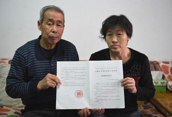 A verdict granting State compensation of more than 2 million yuan ($322,000) is displayed on Dec 31 by the parents of Hugjiltu, an 18-year-old wrongly executed for rape and murder, in Hohhot, the capital of the Inner Mongolia autonomous region.[Photo/Xinhua]  