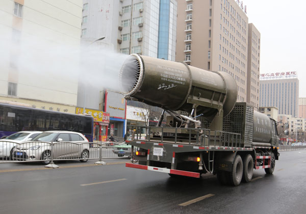 A specially designed truck sprays mist to reduce dust in the air in Zhengzhou, Henan province, on Tuesday. The vehicle is said to be able to alleviate smog effectively. Yang Zhenghua / For China Daily  