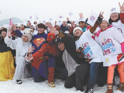 Children pose with cartoon characters at a ski resort in Beijing on Sunday, which was World Snow Day. To promote snow sports, 15 ski resorts across the country offered free ski classes to children ages 4 to 14 on Sunday. WEI XIAOHAO/CHINA DAILY  