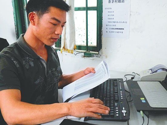 Wang Qingcong, a postman in Fanmao village, Hainan province, helps villagers to pay electricity bills online at his office in the village. He quit his job in the city and returned to his hometown to work as a postman. (Liu Xiaoli/China Daily)