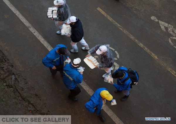 Volunteers provide food to rescue workers in Taipei, southeast China's Taiwan, Feb. 8, 2015. Non-governmental organizations provided free food to rescue workers since the TransAsia Airways plane crashed on Feb. 4. (Xinhua/Jin Liwang)