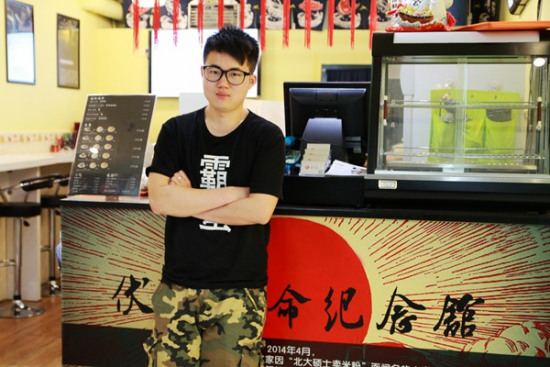 Zhang Tianyi, wearing a black shirt bearing the wordsBa Man, which in Central China's Hunan dialect means stubborn and hardworking, in his restaurant in the Beijing CBD, on April 14, 2015. (Photo/Song Wei)