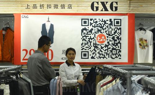 O2O SHOPPING: Customers try on clothes at a GXG fashion store in Hangzhou, Zhejiang Province, on May 4, 2014. They get coupons online and pay through WeChat either in or out of the store (LONG WEI)