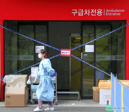 A medical worker walks past a hospital, where 7 patients were infected with MERS, in Seoul, South Korea, June 6, 2015.(Photo: Xinhua/Yao Qilin) 