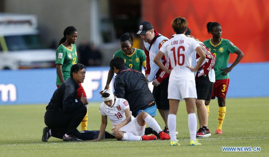 Han Peng (Bottom) of China gets injured during a round of 16 match between China and Cameroon at Commonwealth Stadium in Edmonton, Canada on June 20, 2015. China won 1-0. (Xinhua/Qin Lang)