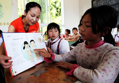 A teacher in Luzhou, Sichuan province, shows students inappropriate touching places during a class designed to raise children's awareness of how to protect themselves. Liu Chuanfu/for China Daily