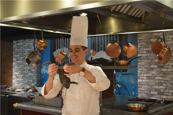 French chef Mikolajczak Yann prepares a frog dish. (Photo by Jiang Wanjuan/chinadaily.com.cn)