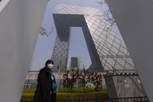 A woman wears a mask while walking on Guanghua Road in Beijing on April 9, 2015 as the city is shrouded in haze for a second day. (Photo: China Daily/Wei Xiaohao)