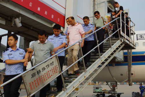 China repatriates first economic fugitive from Spain Two economic fugitives (second and fourth) are repatriated on Aug 3, 2014 from Cambodia after fleeing overseas with illicit assets. (Photo/China Daily)