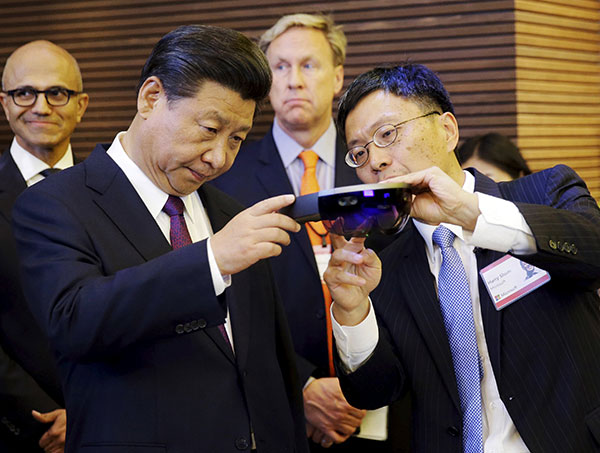 Microsoft's Harry Shum shows Xi a holographic device. (Photo/China Daily)