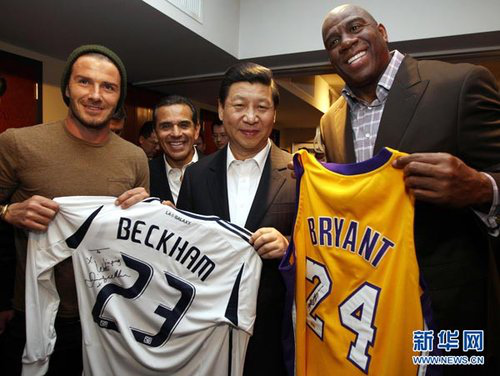 Former Lakers player Earvin Johnson (R) gives President Xi a shirt with NBA star Kobe Bryants signature on it, and David Beckham presented a shirt with his own signature on it to Xi in Staples Center, Los Angeles, Feb 17, 2012. (Photo/Xinhua)