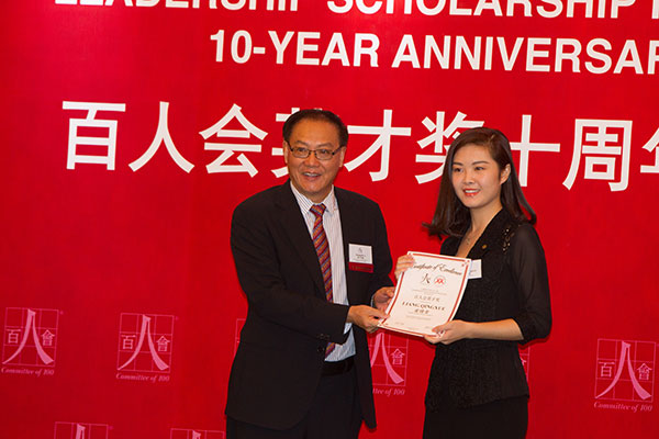 Howard Li, regional co-chair of China of Committee of 100 gives the award to the scholarship recipient Liang Qingxue, student from Shanghai Jiao Tong University on the ceremony. Gao Erqiang / China Daily